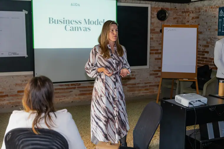 Mentora apresentando o Business Model Canvas projetado durante uma aula.